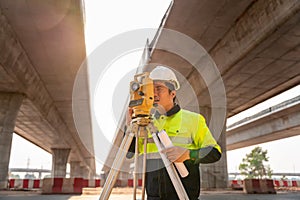 Asian civil engineer or surveyor diligently at road construction site, Surveyor equipment. Highway