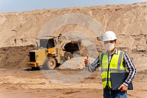 Asian Civil Engineer with Yellow Excavator working at sandpit. sand industry. construction site