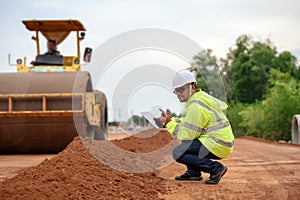 Asian civil engineers inspecting laterite soil for road construction improvement base road work. Inspection of each layer of