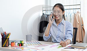 Asian clothing designers are chatting with customers to ask about their needs in creating beautiful and modern designs