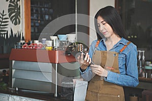 Asian Coffee Shop Owner Accepts a Pre-Order on a Tablet Smiling to the Customer in a Cozy Cafe. Restaurant Manager Browsing