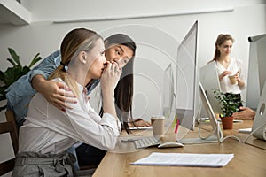 Asian colleague supporting caucasian coworker reading bad news i