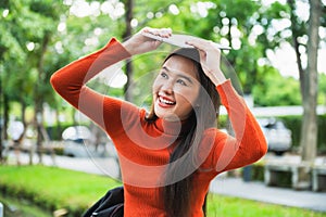 Asian college students sit and smile at a park on campus