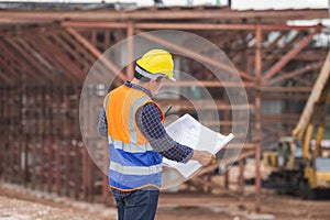 Asian construction engineer checking project at the building site, Architect with a blueprints at a construction site, Foreman