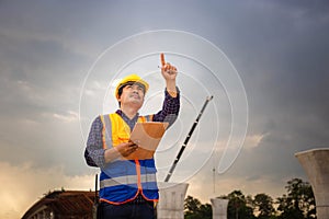 Asian construction engineer checking project at the building site, Foreman worker in hardhat at the infrastructure construction