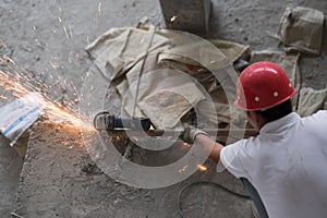 Asian Construction Worker Cutting Metal Sparks