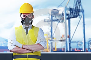 Asian construction worker with hardhat and safety mask standing with crossed arms