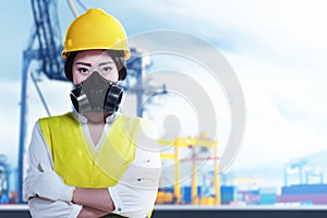 Asian construction worker with hardhat and safety mask standing with crossed arms