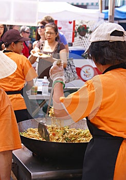 Asian cooks serving food at concessions.