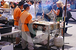 Asian cooks serving food at concessions.