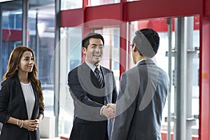 Happy asian business people shaking hands photo