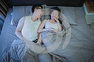 Asian couple with bad breath issues on bed at night