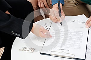 Asian couple buying new house sign contract with realtor at new home,Close up hand of couple purchase apartment