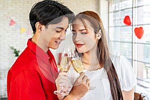 Asian Couple drinking champagne standing in living room. Valentine concept