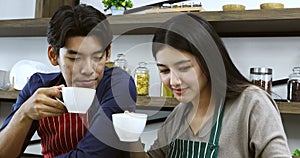 Asian couple drinking coffee in kitchen together.