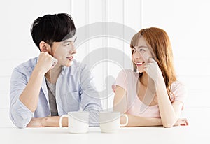 Asian couple drinking coffee in living room