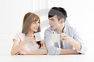 Asian couple drinking coffee in living room