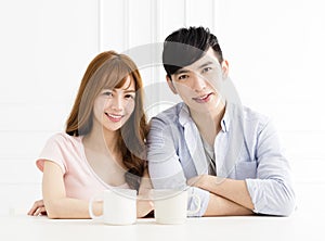 Asian couple drinking coffee in living room