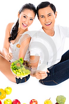 Asian couple eating salad fruit