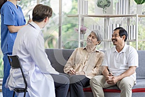 Asian couple Elderly men and women sit on sofas having fun and having fun talking with doctors who come to check their health at