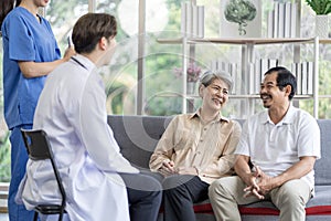 Asian couple Elderly men and women sit on sofas having fun and having fun talking with doctors who come to check their health at