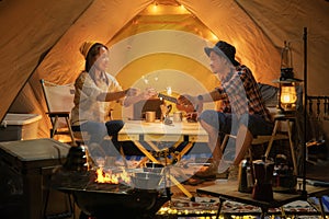 Asian couple enjoy in they tent in camping trip on night time