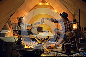 Asian couple enjoy in they tent in camping trip on night time with many star on the sky