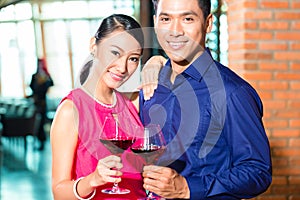 Asian couple with glass of red wine