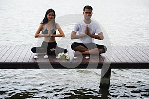 Asian couple hand yoga at lake