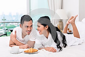 Asian couple having breakfast in bed