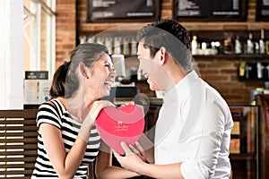 Asian couple having date in coffee shop with red heart