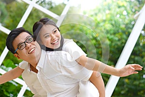 Asian couple having piggyback fun