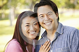 Asian couple head and shoulders portrait outdoors