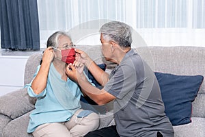 Asian couple, husband helping his wife wear a mask made of cloth, to protect against dusà¸° and germs