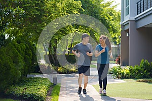 Asian couple are jogging in the neighborhood for daily health and well being, both physical and mental and simple antidote to photo