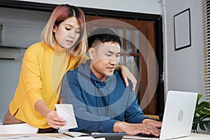 Asian couple list home financial bill budget on table in kitchen at new house.family expense