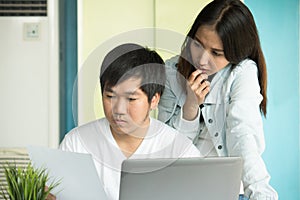 Asian couple looking at issues notification from bank about late payment home loan credit