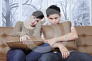 Asian couple looks bored at home