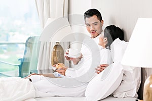 Asian couple lounging in bed