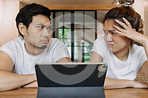 Asian couple lover in cafe get confused with application in the tablet computer