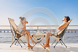 Asian couple lover enjoy their holiday at the sea in the summer with beautiful clear sky ocean view.