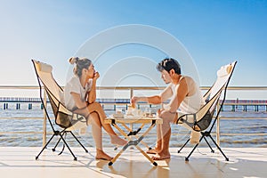 Asian couple lover enjoy their holiday at the sea in the summer with beautiful clear sky ocean view.