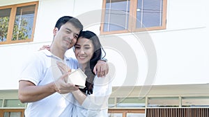 Asian couple with model house ,Happy smiling couple holding a model house. Home insurance concept