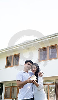 Asian couple with model house ,Happy smiling couple holding a model house. Home insurance concept