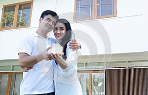 Asian couple with model house ,Happy smiling couple holding a model house. Home insurance concept