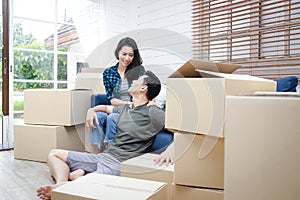 Asian couple moving into a new home Help unpack the brown paper box to decorate the house.