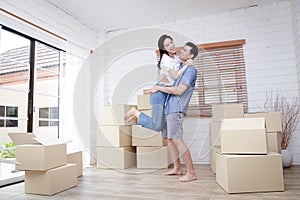 Asian couple moving into a new home jumping together happily