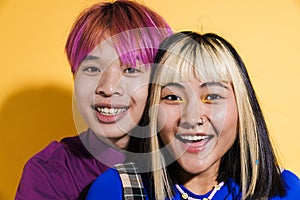 Asian couple with multicolored hair hugging and laughing together