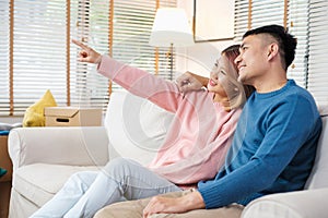 Asian couple planning to decorate house after moving to new home,sitting on sofa with relax emotion