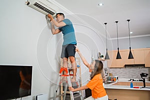 asian couple repair broken airconditioner together photo